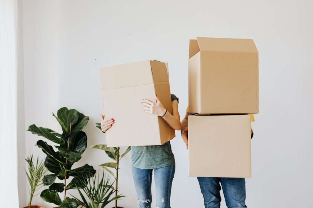 A couple hugging in a room full of boxes while having post-moving burnout.