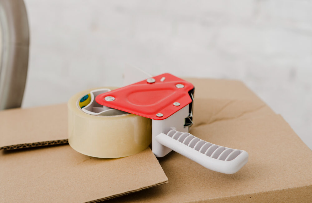 Packing tape dispenser on a cardboard box.