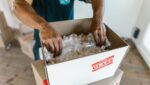 a man putting fragile items in the box.